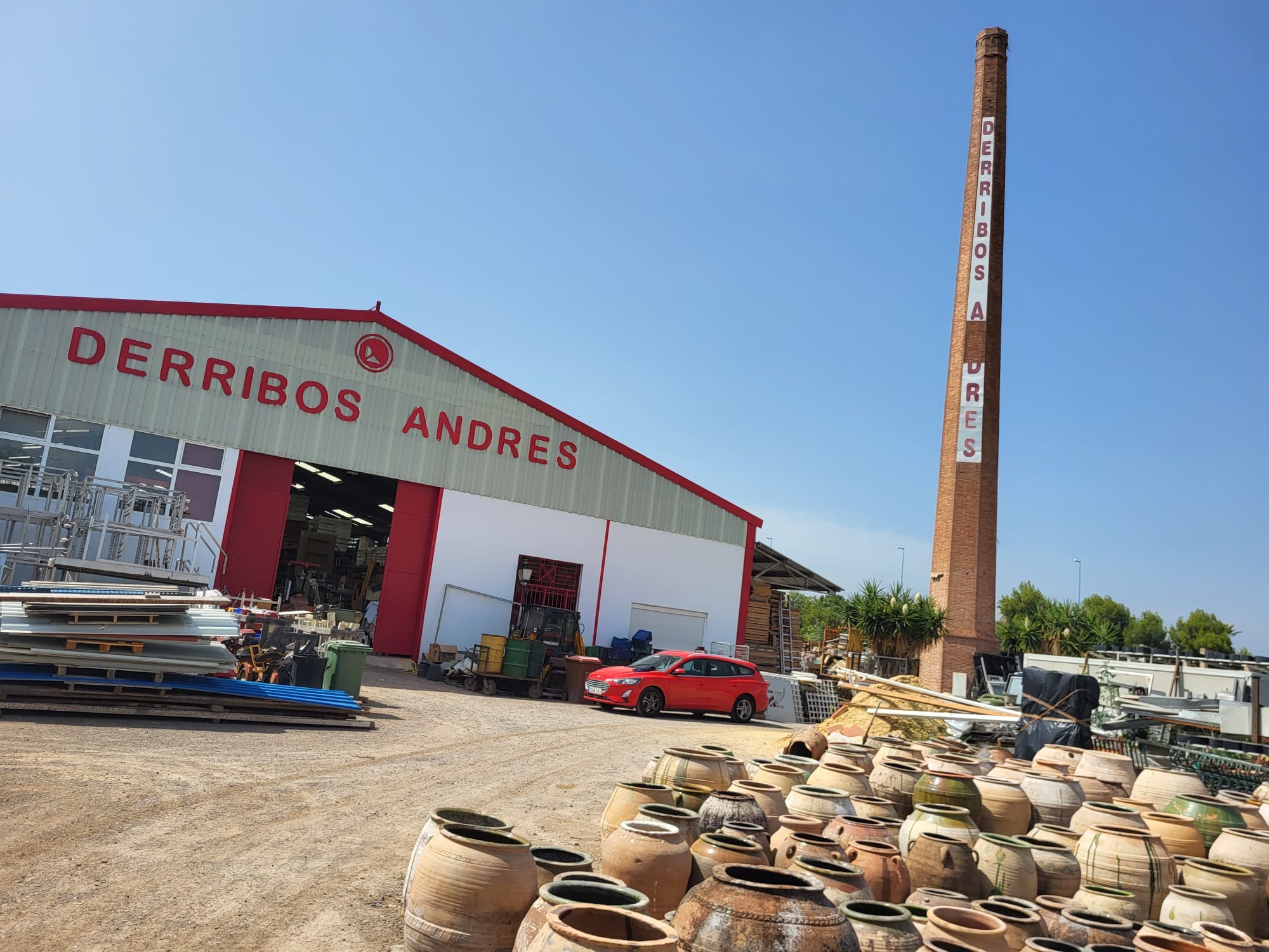 Operarios de Derribos Andrés con equipos de protección EPI, retirando planchas de fibrocemento con amianto (uralita) de una cubierta industrial en Valencia. Empresa autorizada