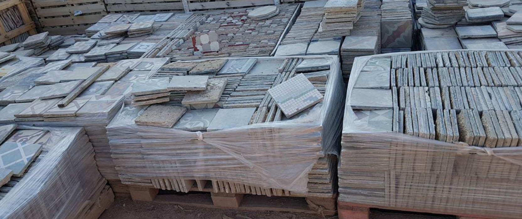 Contenedores de residuos de demolición clasificados (escombros, metales) en un sitio de trabajo, destacando la gestión responsable y el compromiso medioambiental de la empresa
