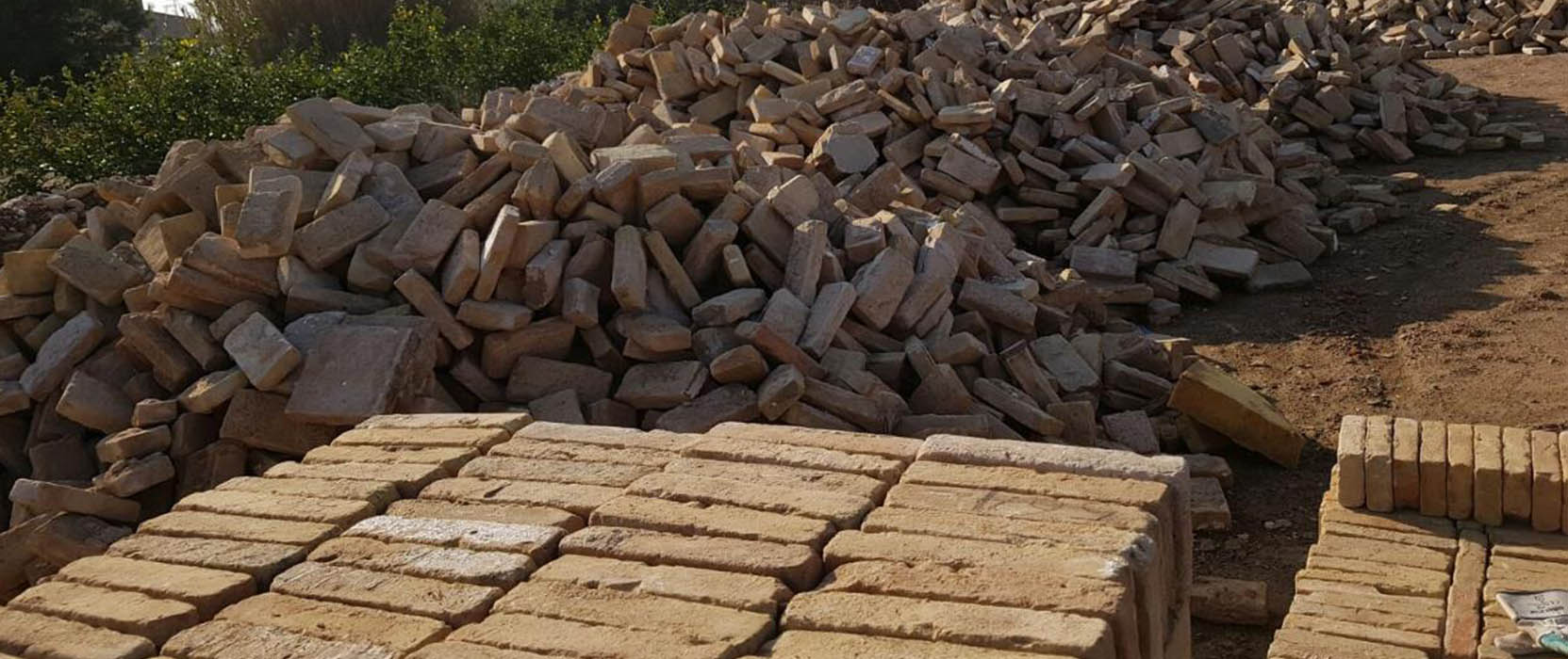 Primer plano de una pila de ladrillos de cara vista o tejas antiguas recuperadas, listos para la venta en la tienda de materiales de construcción de Derribos Andrés